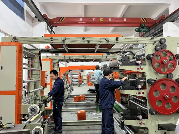 factory workers assemble and debug flexographic printing press